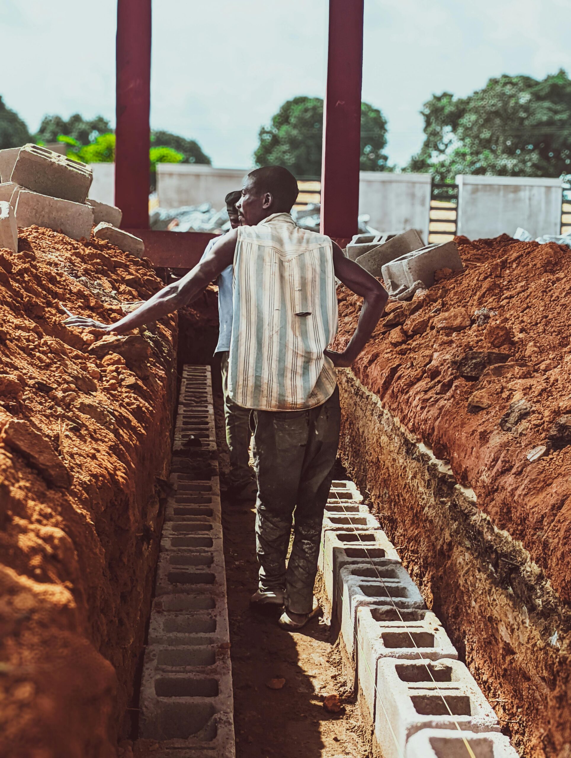 Workers on a construction site laying foundation bricks in Kaduna, Nigeria.