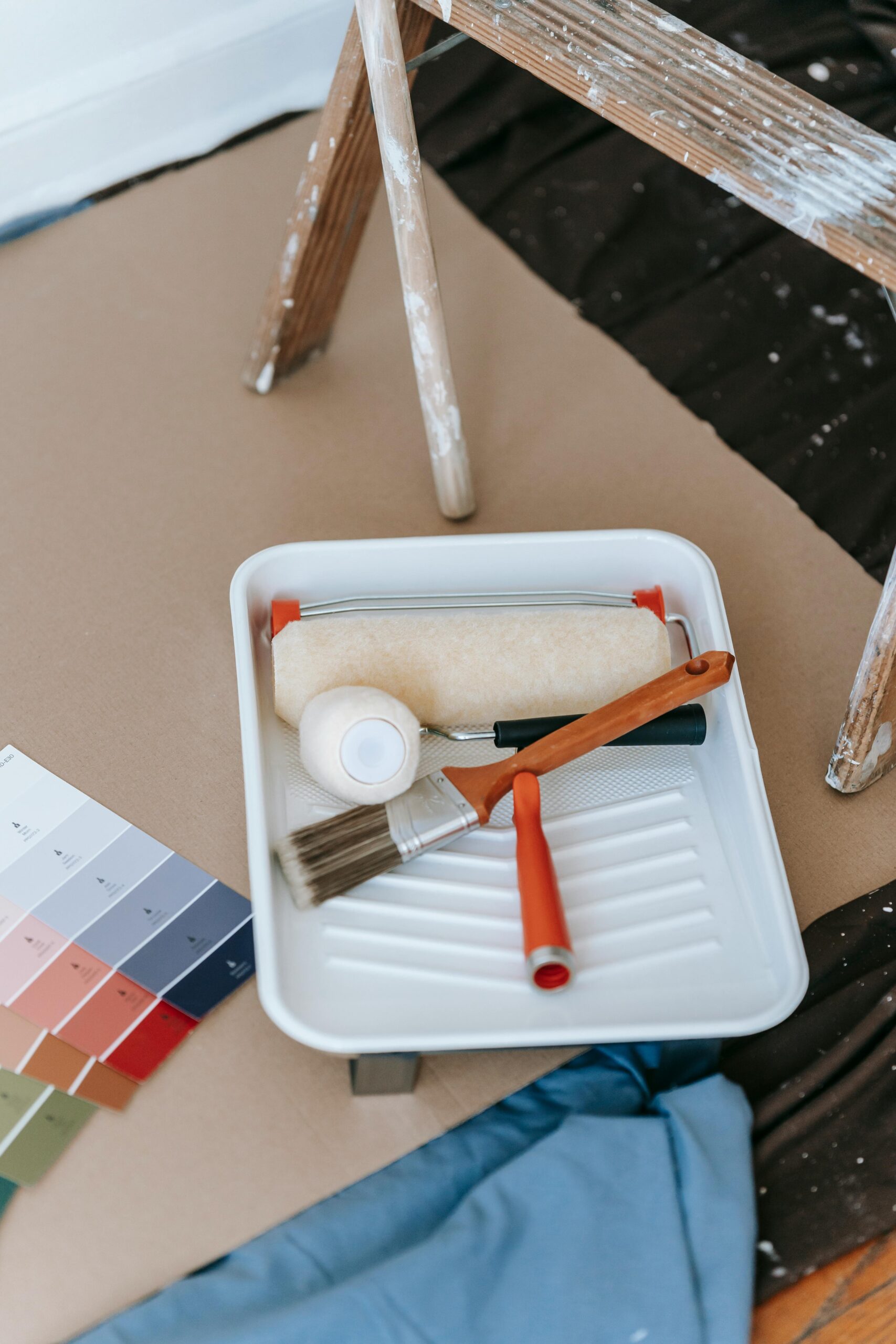 A well-organized setup for a DIY home painting project, complete with tools and color swatches.